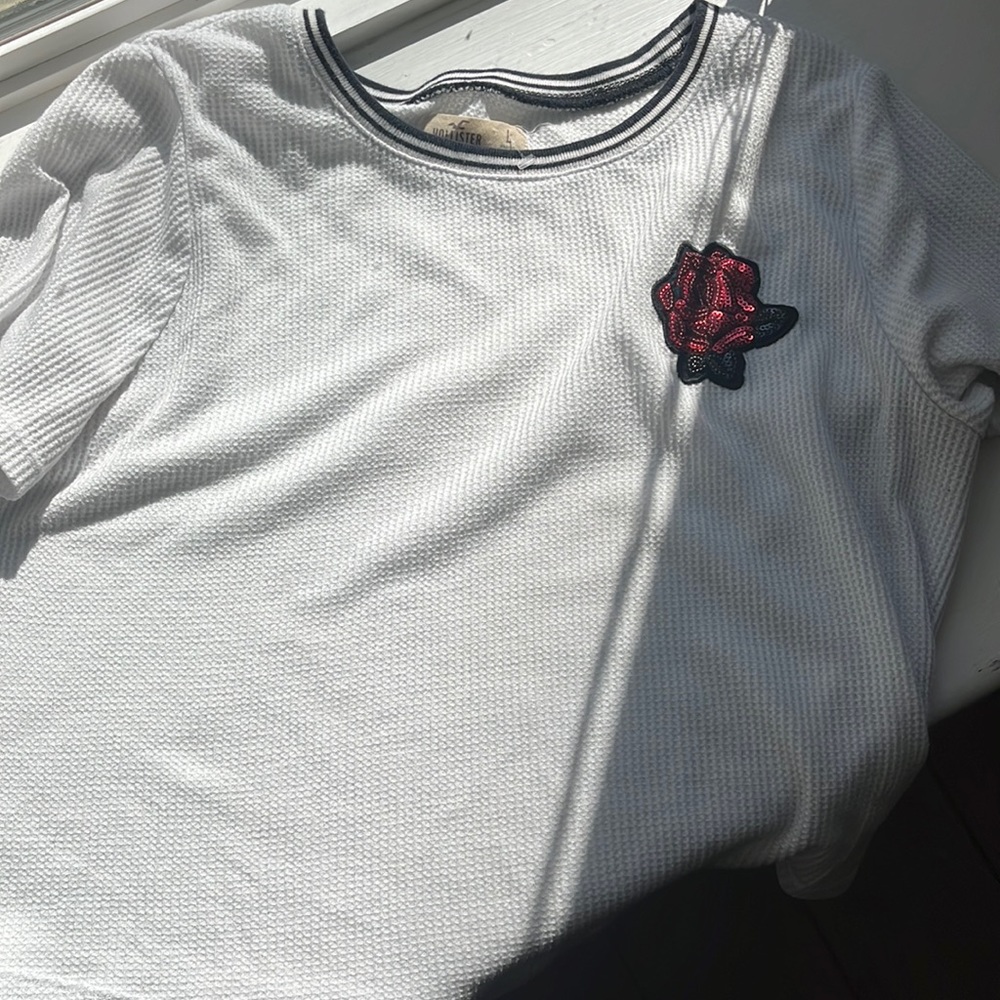 White hollister shirt god condition with a red rose